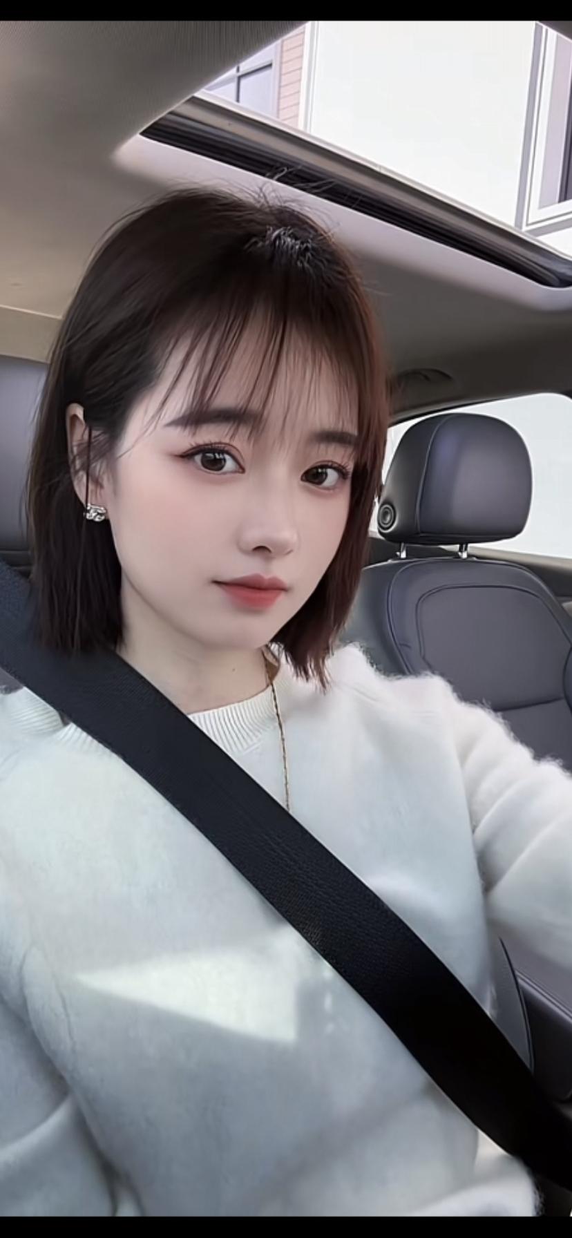 小姐姐坐在车里，系着安全带。