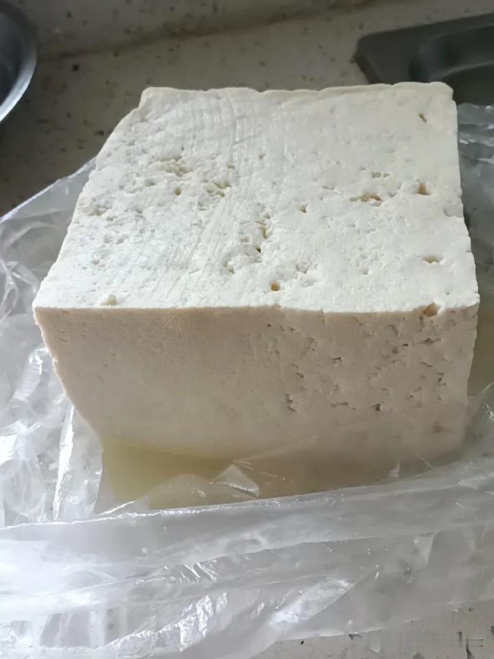 刚去小市场买了一块大豆腐，东北人就喜欢吃卤水豆腐滑嫩爽口，这是5块钱的大豆腐，在