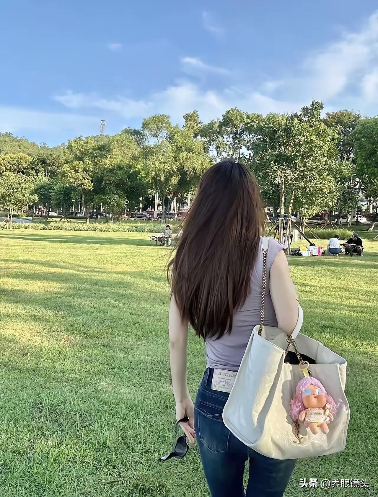 一个长发女孩在公园里散步。