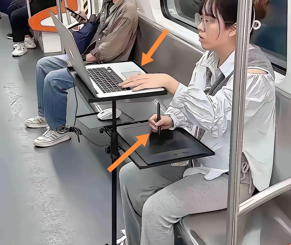 地铁中一姑娘双手上下操作双电脑。