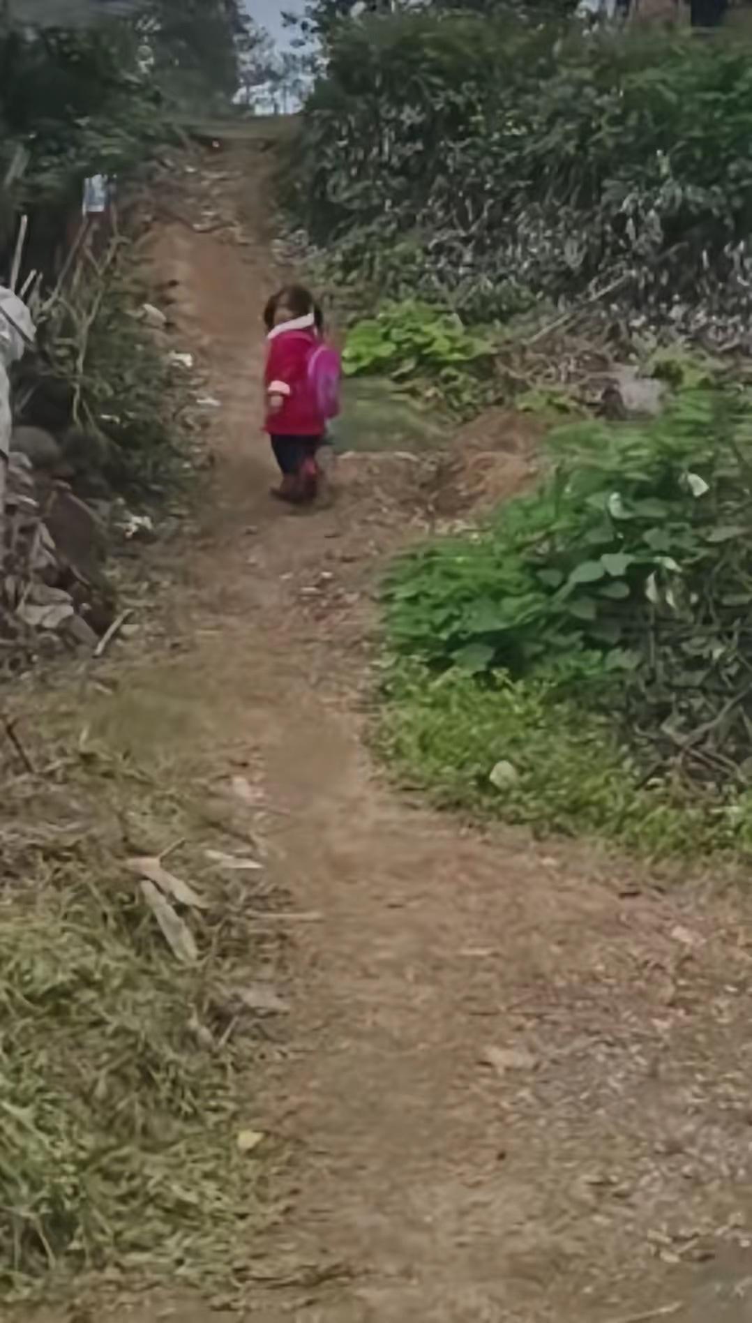 小小的身影，10多米的土路上，小姑娘多次回头，跟在后面的老师，看见小姑娘回头的瞬
