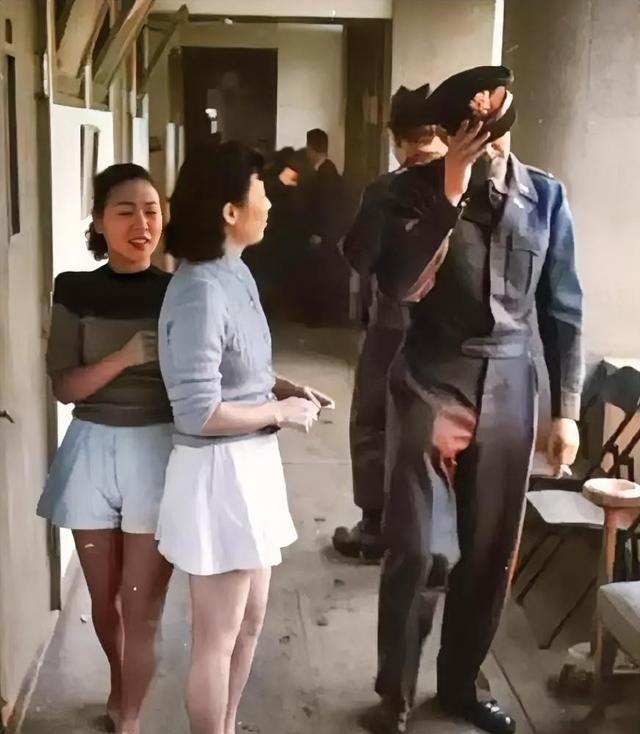 1951年，一名美军军官在日本“基地村”享受完服务后，正准备离开。两名年轻漂亮，