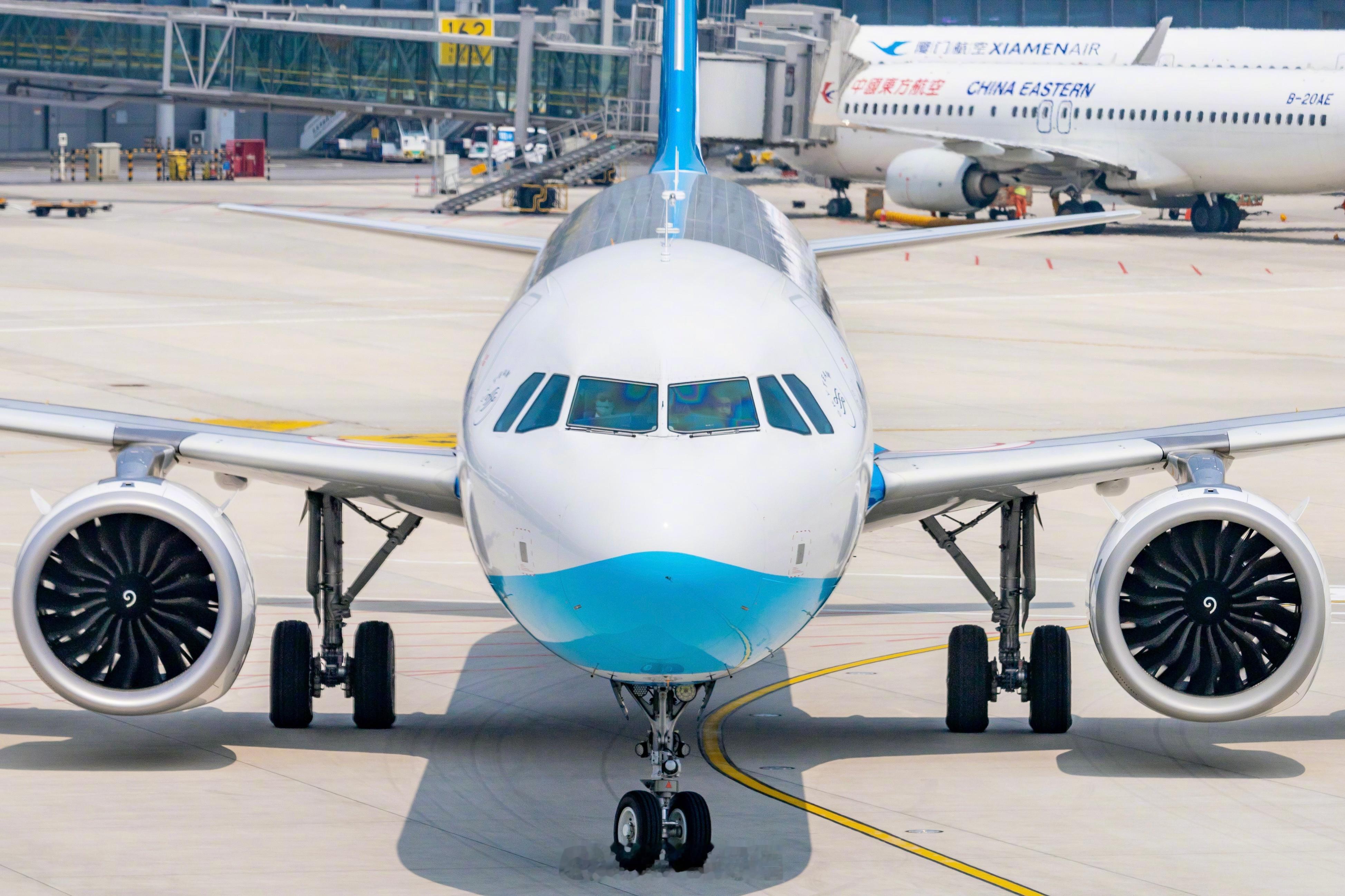 正在转弯滑入停机位中的厦航A321neo，和开车一样，为了后面能更好的对准停机线