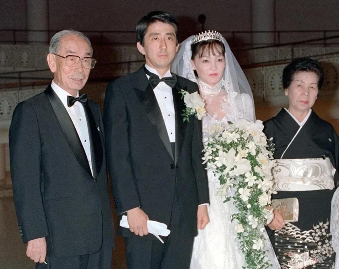 1987年，安倍的结婚典礼现场，照片上的他穿着光鲜亮丽的西装，妻子则身着纯洁的白