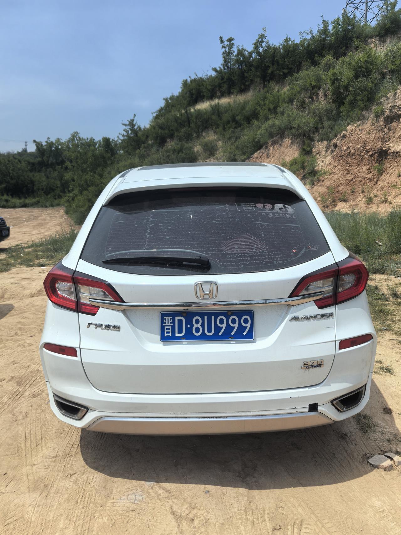 一辆时尚的白色小车，静静停在郊外的小路边，车牌号是D·8U999，周围风景如画。