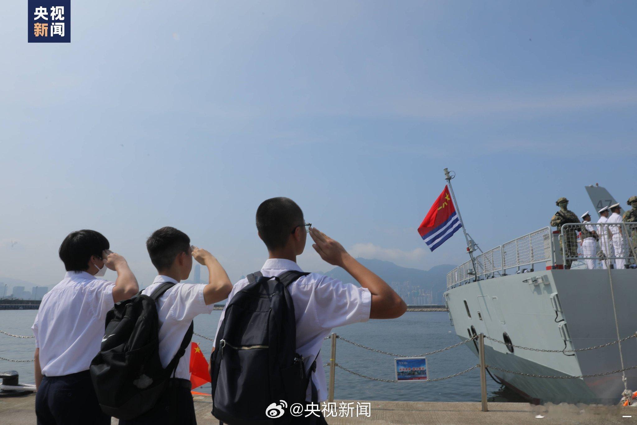 湛江舰今天离码头时，3名香港中学生向悬挂在舰尾的海军军旗敬礼：山东舰编队访问香港