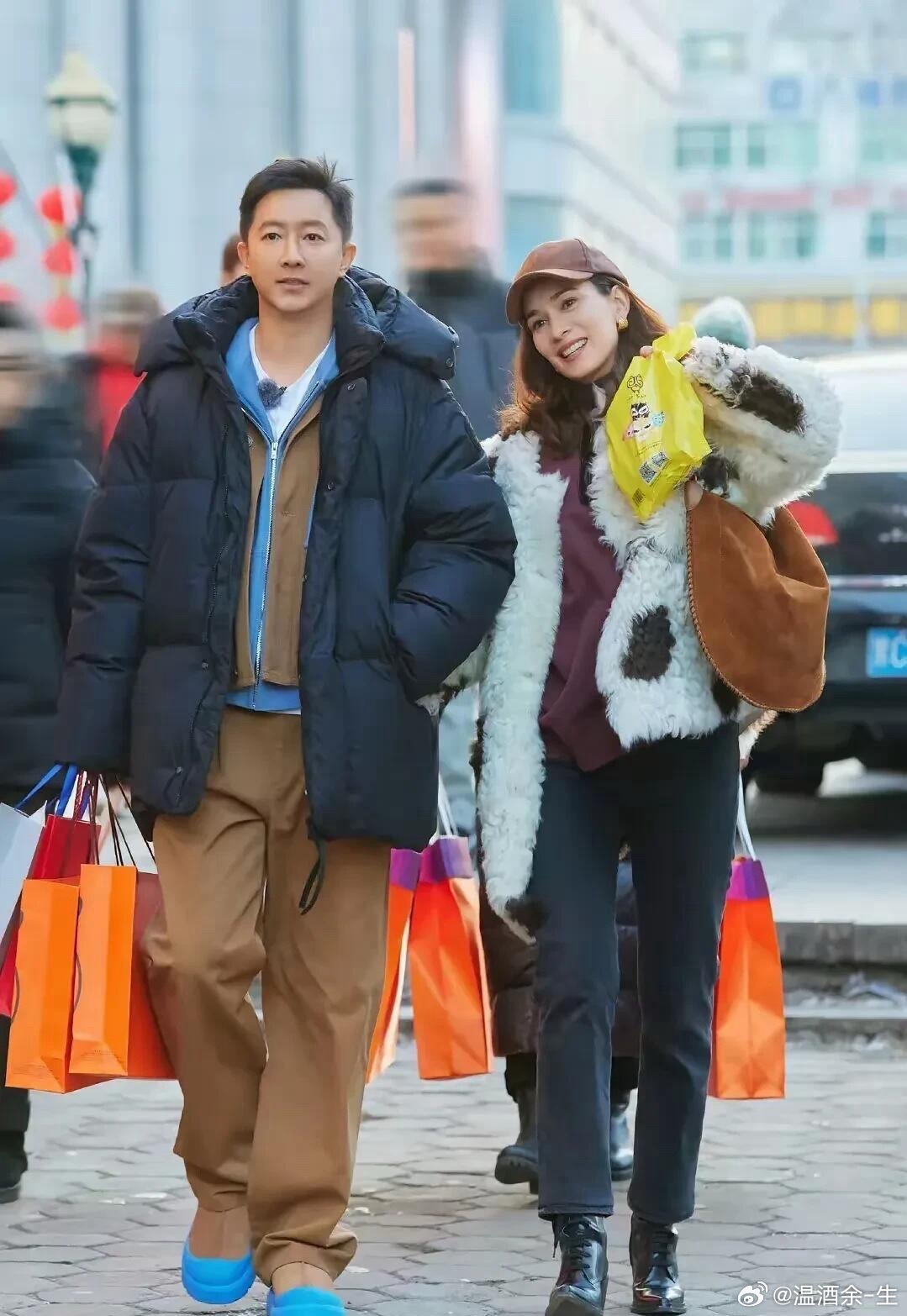 这对明星真挺接地气的，夫妻俩一起逛街买东西，拎了不少大包小包的。男的是演员韩庚，
