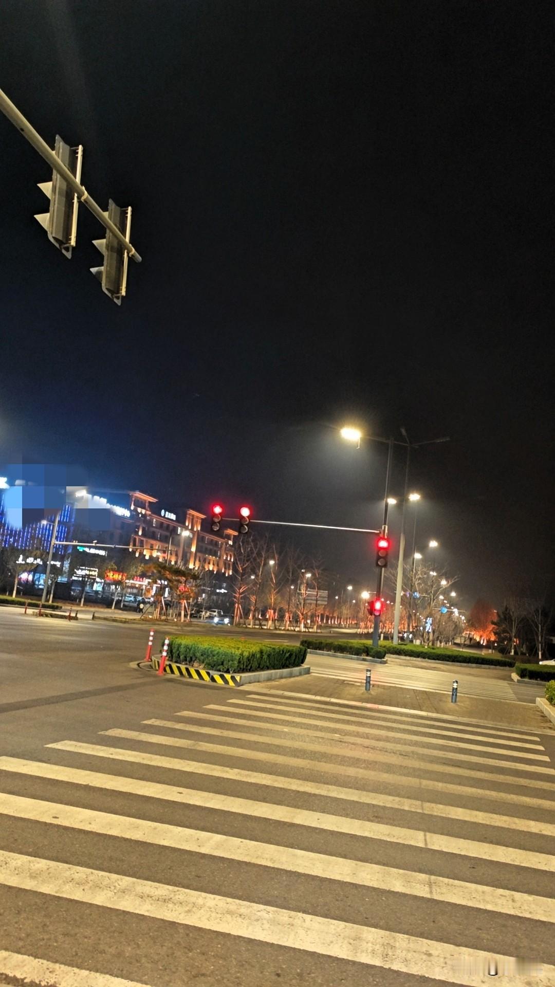 晚上走在路口，红绿灯在黑夜里亮得特别显眼，路灯的光柔柔地铺在斑马线上。

旁边的