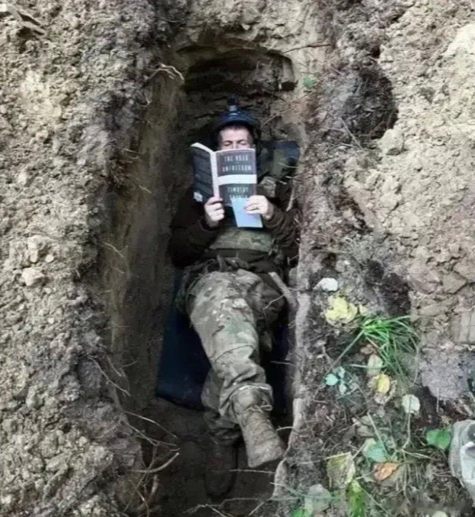 一名年轻的乌克兰士兵在读书。如果在前苏联时代，他应该是躺在草地上读《钢铁是怎样炼