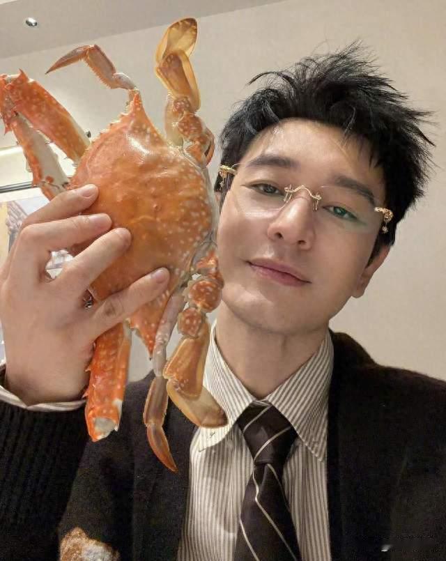 黄晓明只手拿着一只硕大肥美的梭子蟹，搅劲万千网友的欢声笑语。