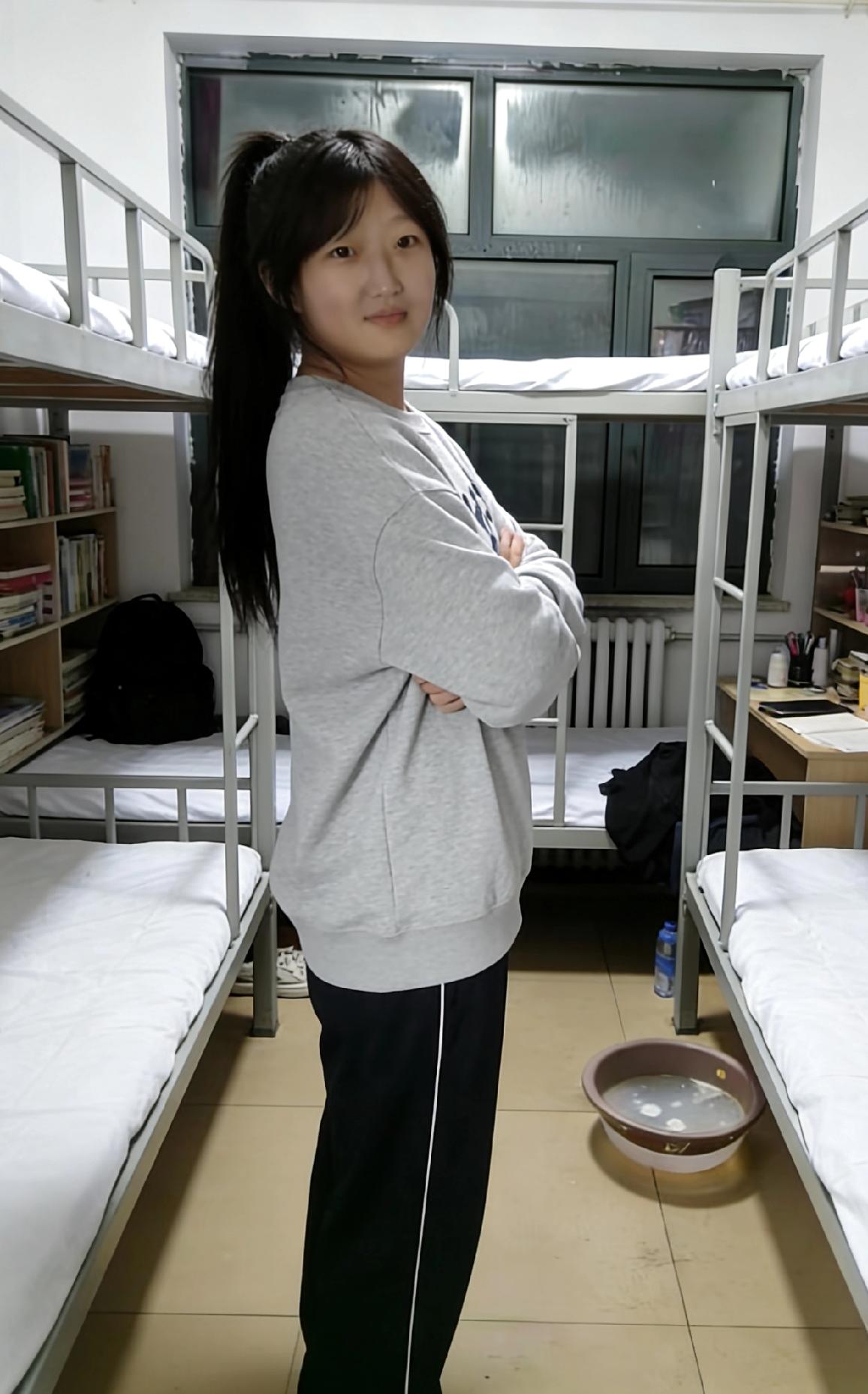 上下铺的铁床，框住青春的形状
她站在中间，灰卫衣是揉过的云朵
马尾辫翘着，像未被