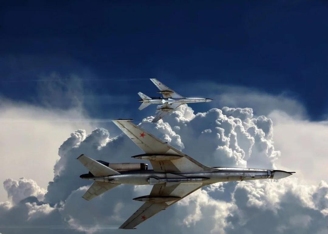 画面中是两架带红星标志的苏联远程轰炸机Tu 22 m在云海上方编队飞行，光影和云