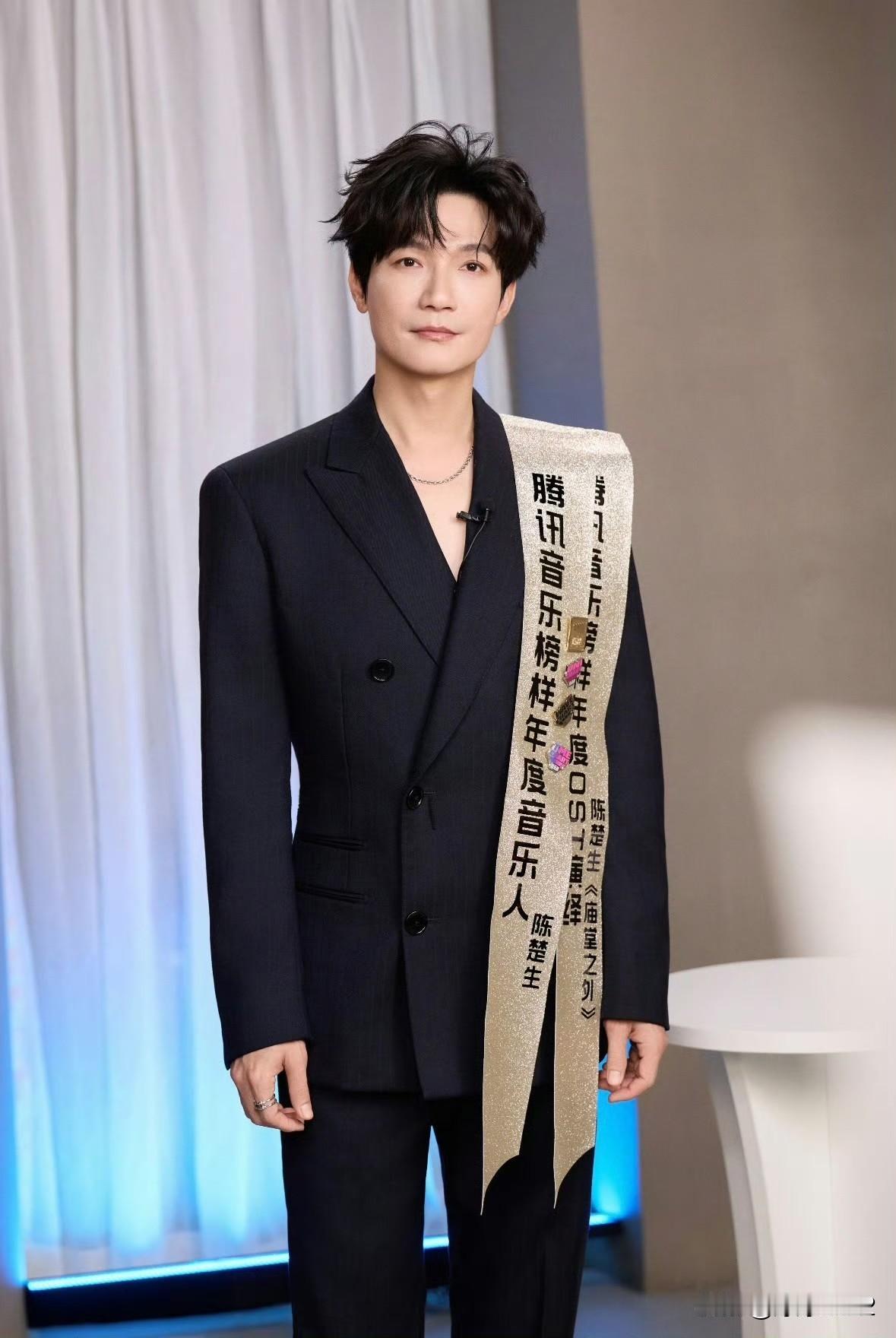 陈楚生 好像在参加选美比赛！
真空黑西装佩戴两条绶带，
一个获奖音乐人，看着像时