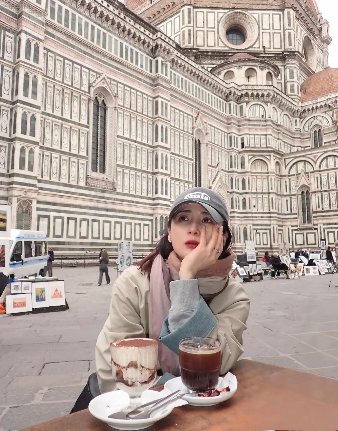 蒋勤勤在社交平台分享了一组佛罗伦萨旅行随拍，她身着米色长款风衣漫步于古城街巷，优