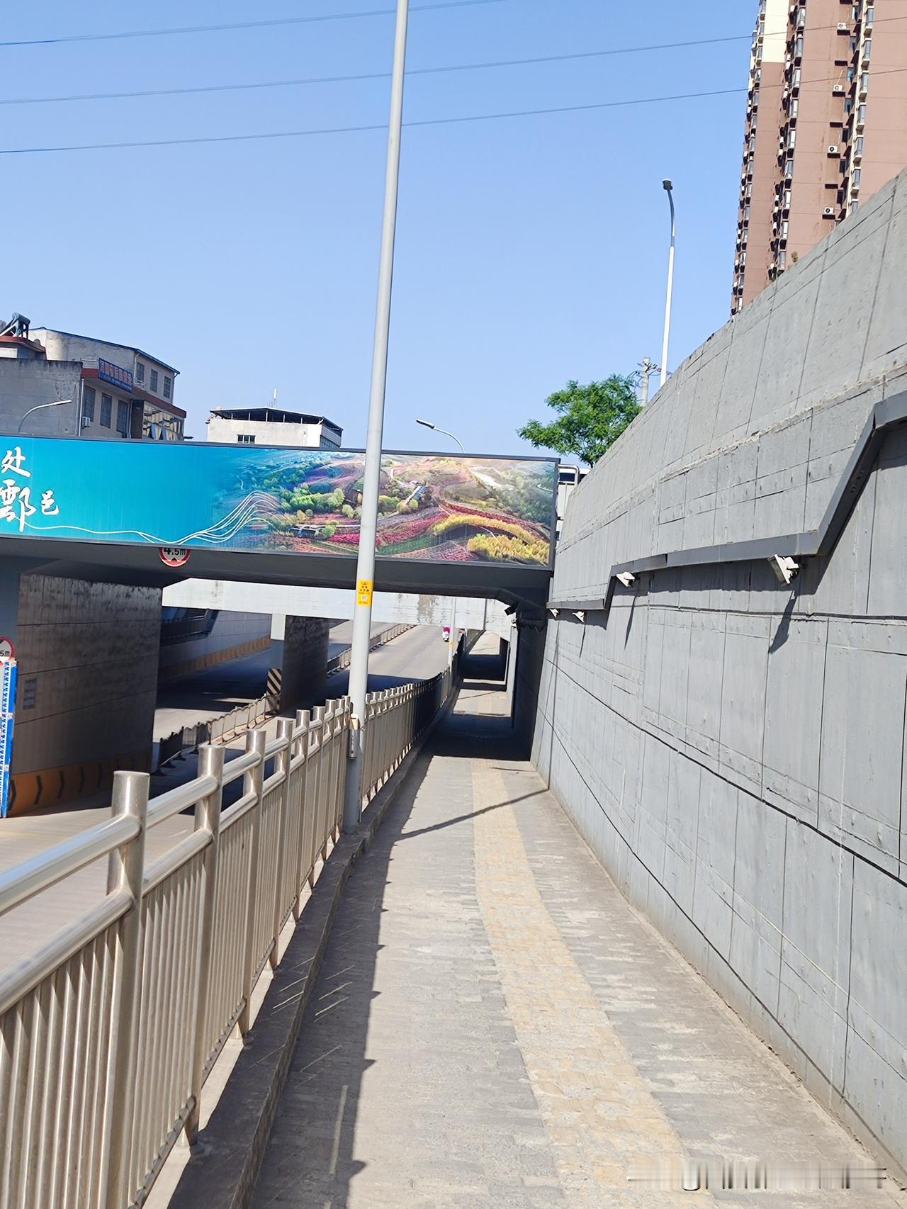 鄠邑三球仪东铁路桥洞人行道口旁的地砖，那状况简直不忍直视。和里面平整完好的地砖一