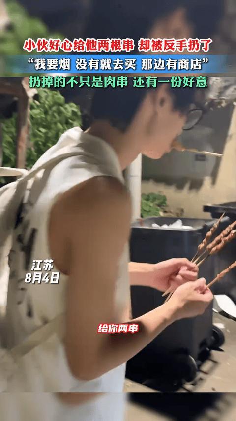 善良被辜负！江苏南通小伙边吃烤串边走着路，结果偶遇一流浪大爷，倚在垃圾桶旁。
