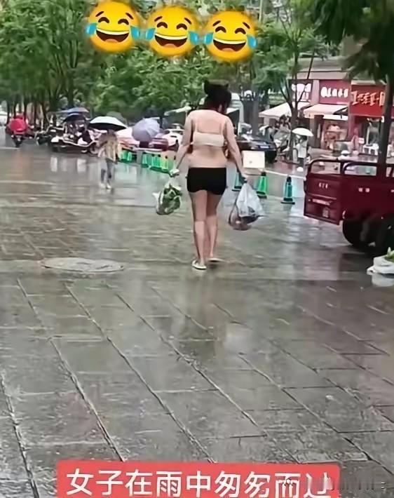 一段雨天街头视频火了。女子穿浅色抹胸、黑色短裤，脚踩拖鞋，手里拎着塑料袋在湿漉漉