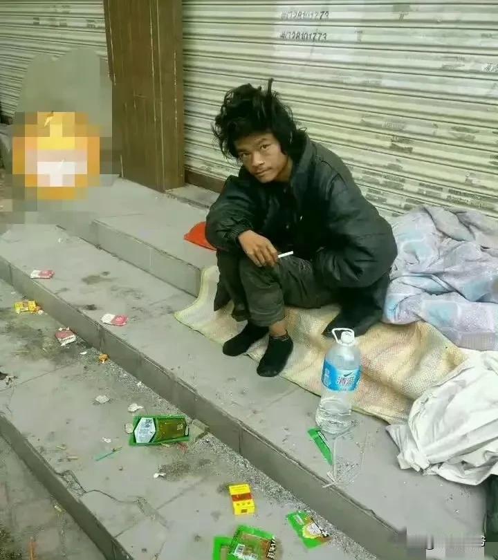 初冬时节的深圳龙华街头，气温只有15度，坐在路边的这位“三和大神”，看起来依然非