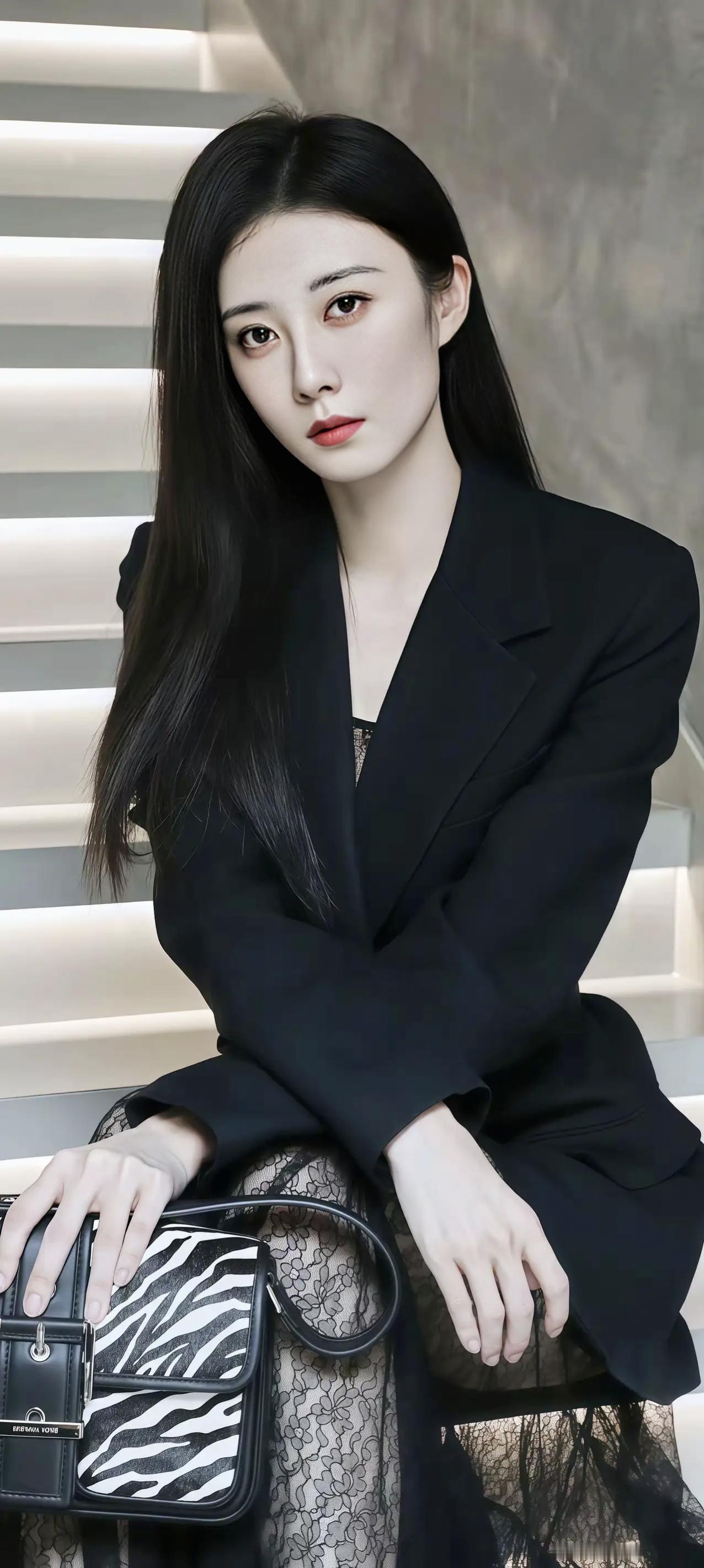 一个穿黑色西装的美女坐在楼梯上。职业西装女神范 气质西装女神