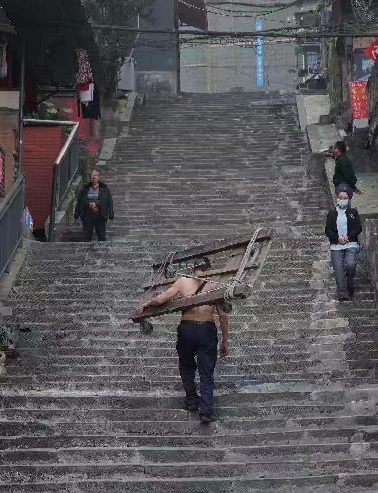 2007年那根竹棒，现在换成了电动板车。货还是那些货，楼还是那些楼，只是冉光辉后