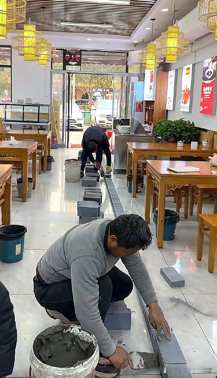 这是两夫妻分家了，这餐馆是要“一分为二”
 
小吃店里俩师傅蹲地上铺青砖，一人占