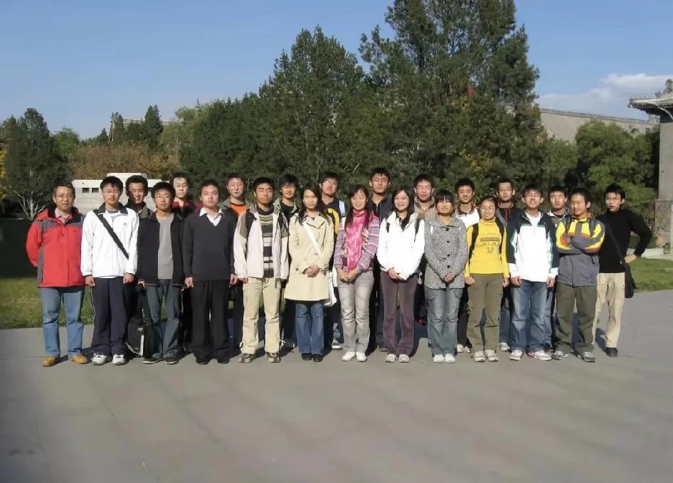 这是一组王虹教授在北大的照片，照片中有学生穿风衣，有学生穿羽绒服。
她穿着黄色卫