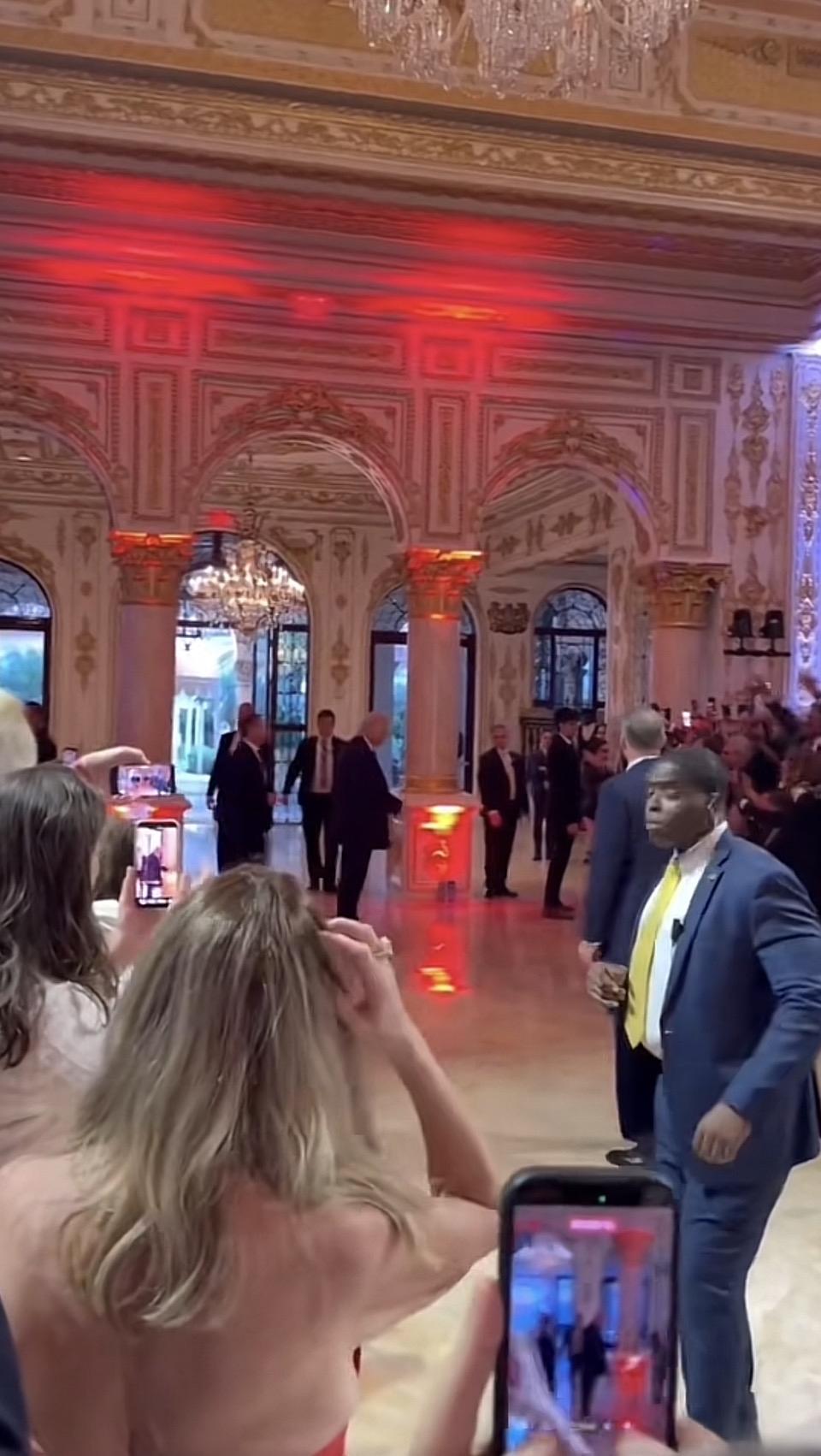 一群西装革履的人在豪华大厅里交谈。