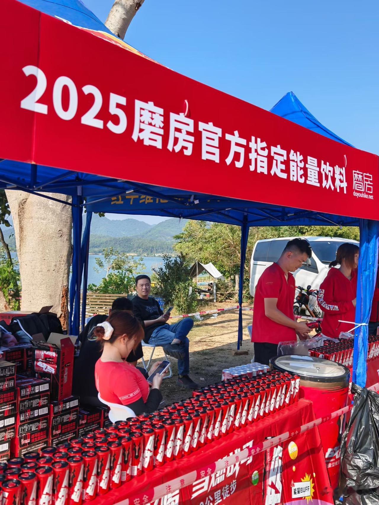 走到2025磨房徒步的补给站，一眼就被这片红色晃了眼——红彤彤的横幅上印着“官方