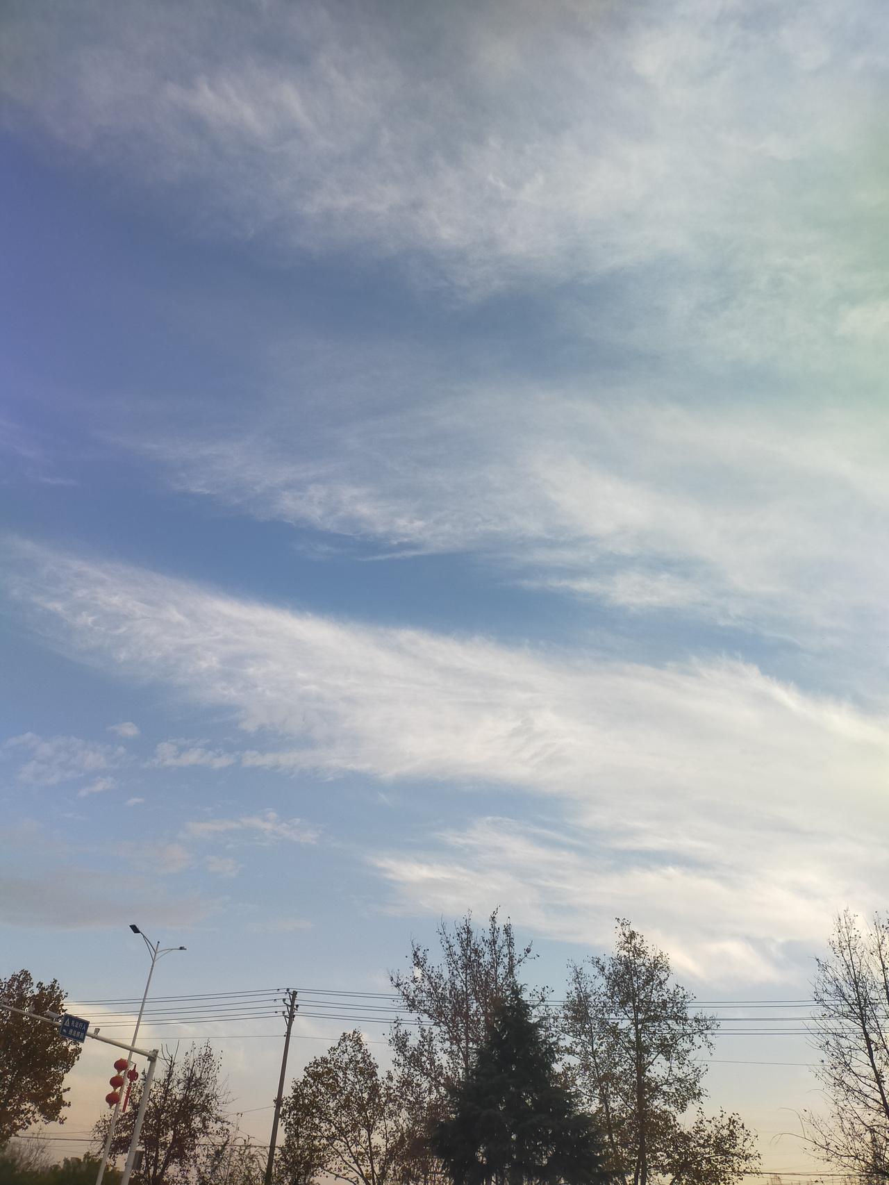 抬头瞅见这天空，蓝得透亮，云跟被扯散的棉花似的，丝丝缕缕飘着，风一吹像要化在天里