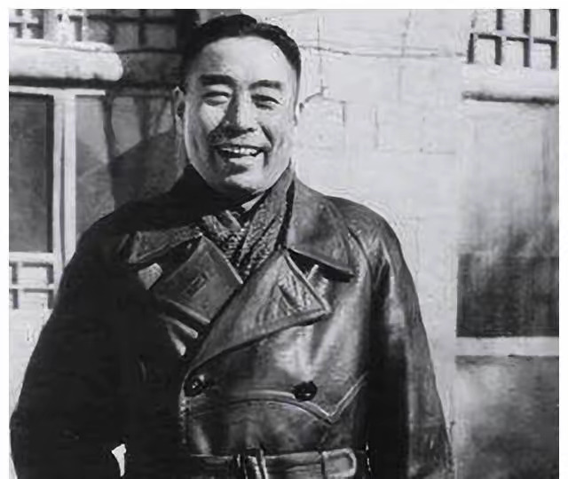 周总理身穿标志性的皮大衣，笑容温暖明亮，尽显革命时期的从容与英气。这张延安时期的