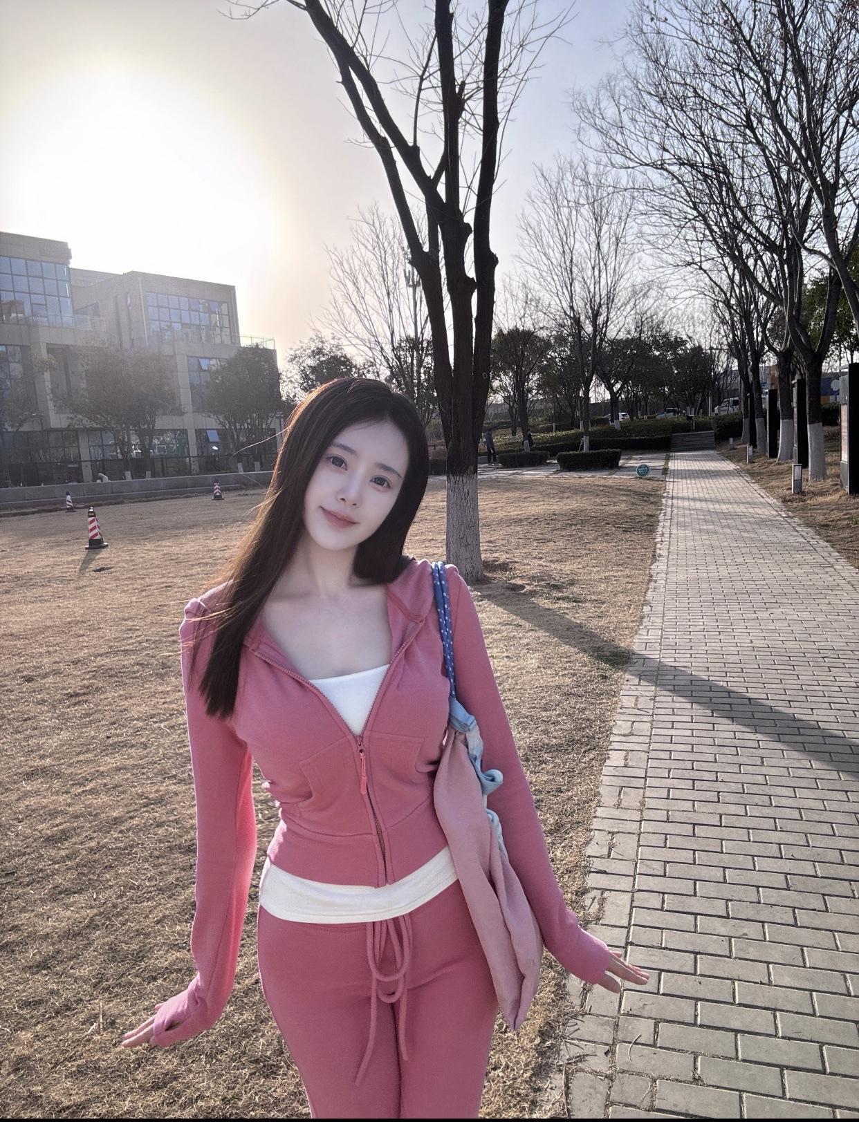 粉衣美人倚树旁，笑语盈盈意自闲。