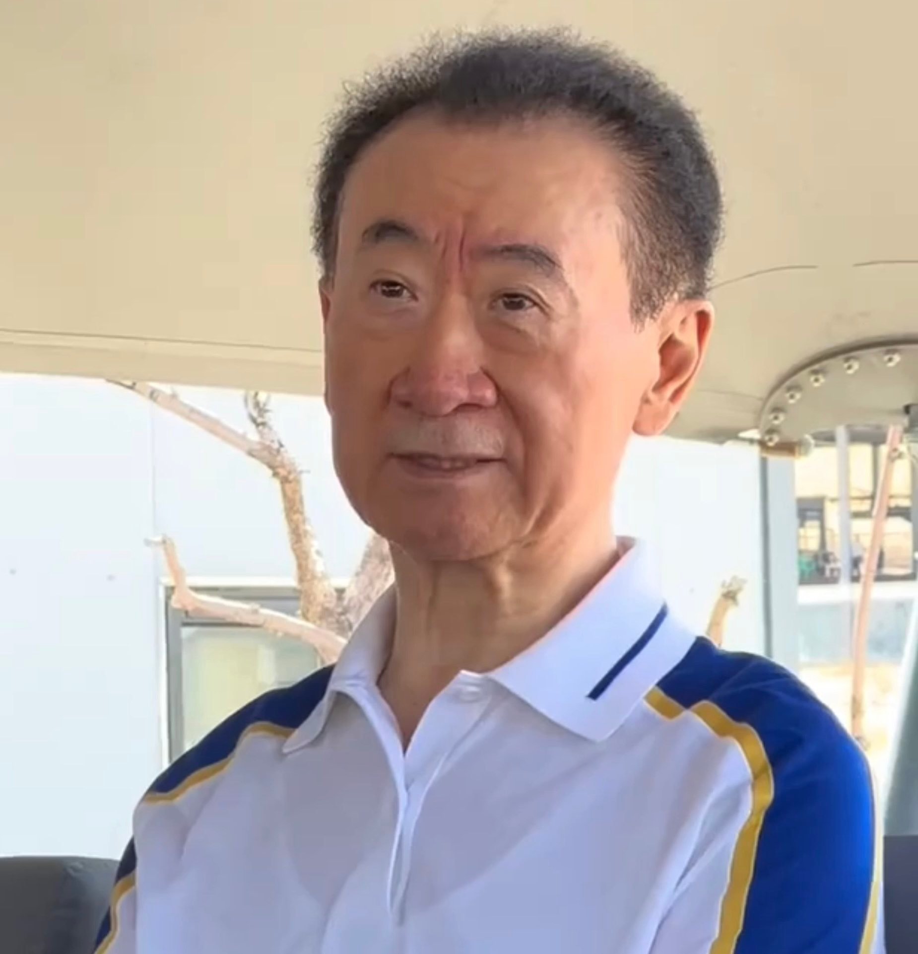 72岁的王健林身形消瘦、颧骨突出，背部已微微佝偻，十年前那个红光满面的首富，如今