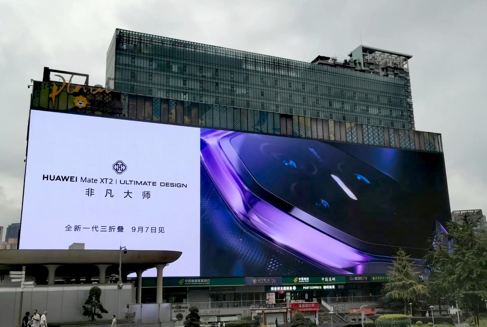 华为新三折叠外观首曝重庆商圈大屏提前放出新机外观，紫色机身搭配细腻纹理看着氛围感