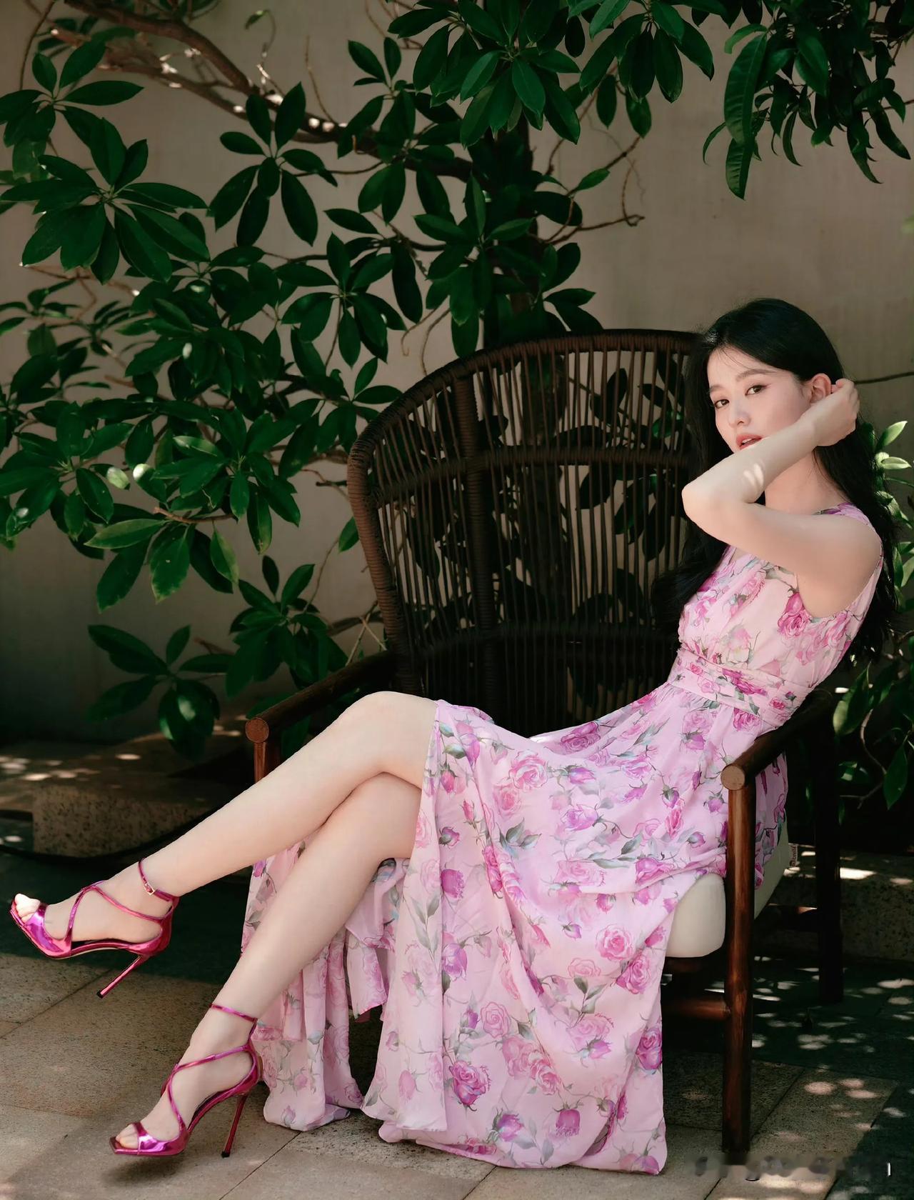 坐在藤椅上，背景是绿植，感觉特别放松。乔欣