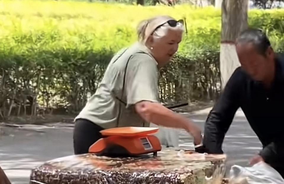 两位老人在路边摊称东西。