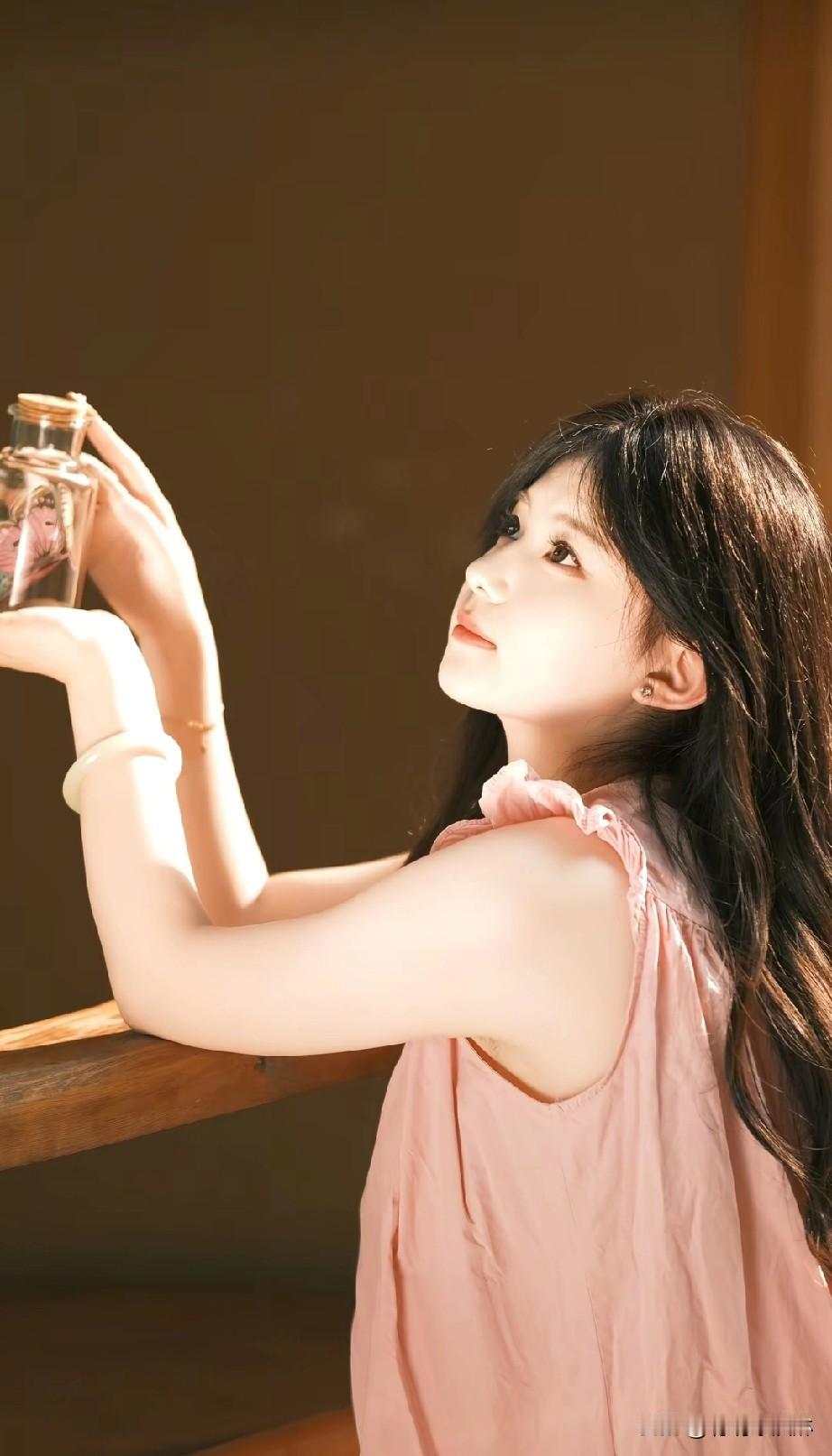 少女手持香水瓶，温柔微笑，散发迷人魅力。