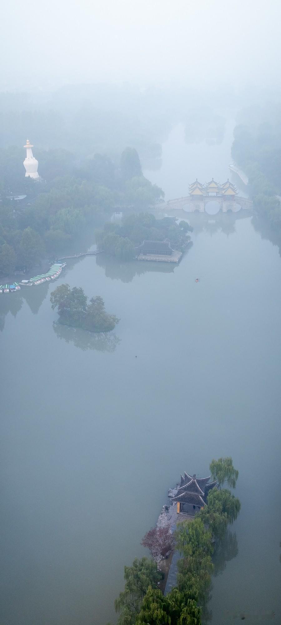 沿着扬州瘦西湖边的步道走，柳条带着湿气垂下来，空气里满是清新的草木香。雾珠挂在荷