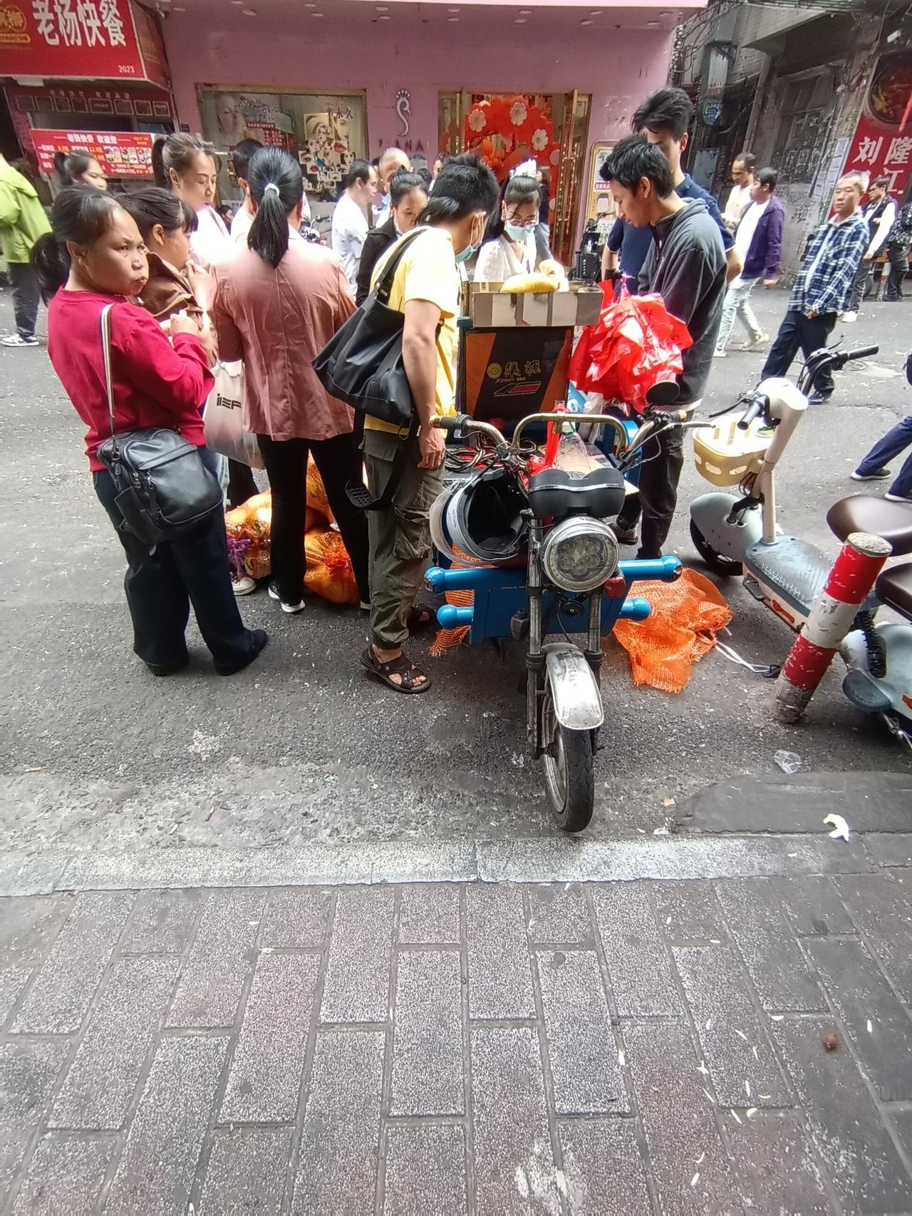 广州海珠区桥南新街卖柚子的商贩生意非常火爆，买柚子的顾客非常的多，只要五块钱一个