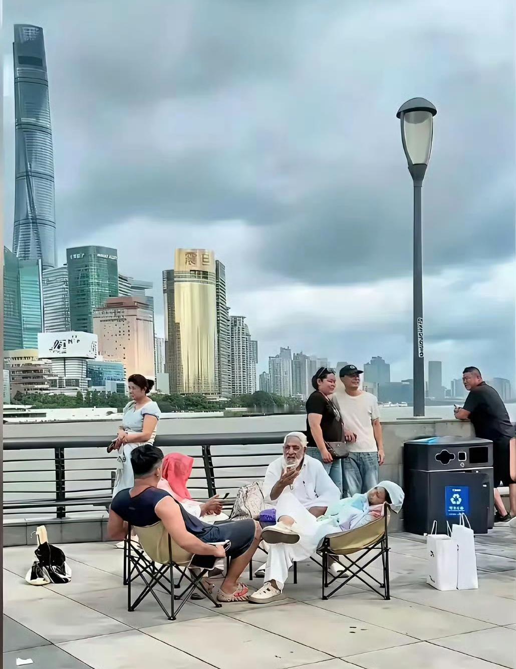 印三的高种姓家庭来上海旅游！
他们将折叠桌椅带到了外滩，一家子旁若无人随意坐卧，