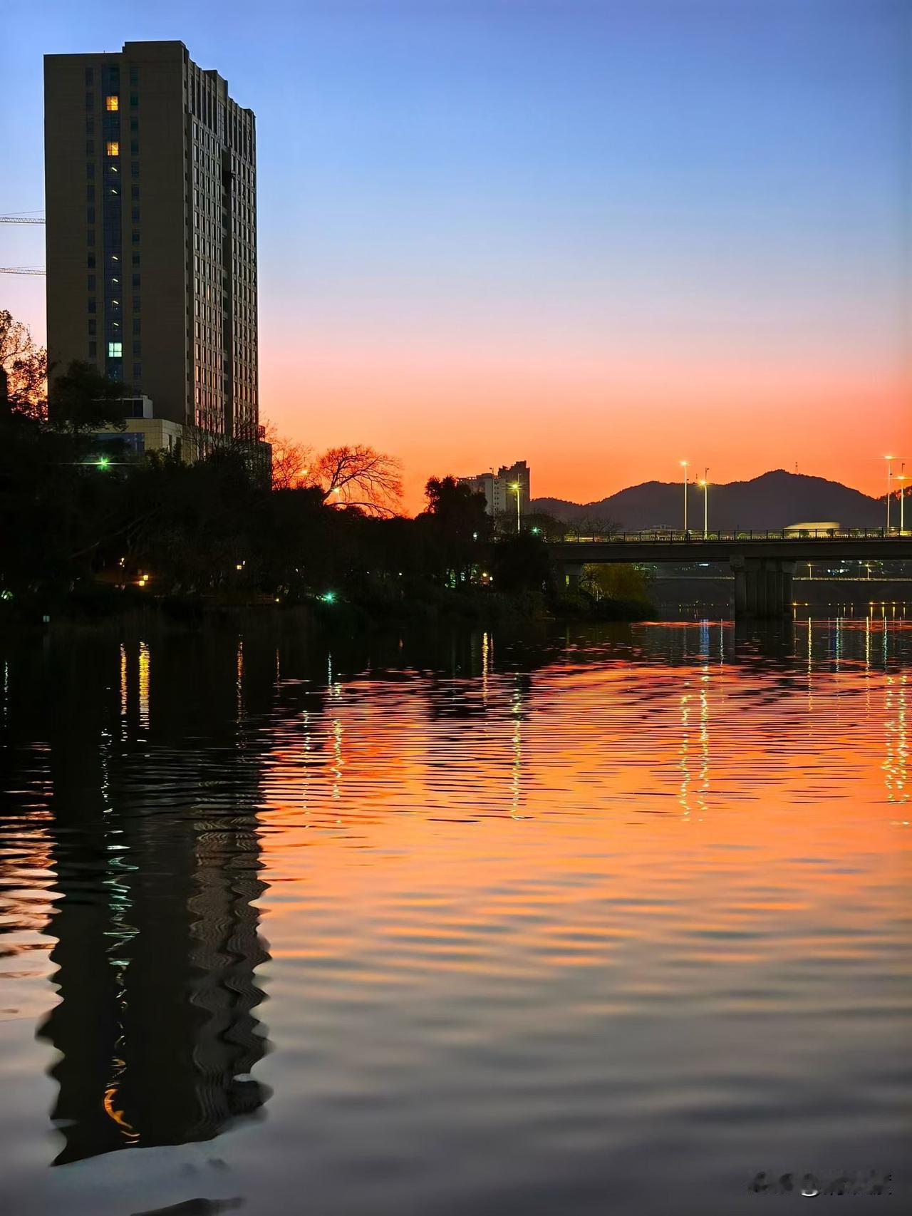 傍晚在河边散步，偶遇超美的晚霞，瞬间被温柔治愈。
橘红色的天空像被打翻了颜料盘，