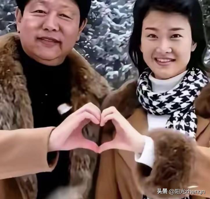 宋祖英和她的丈夫罗浩并肩而立，两人一起用手比出爱心的形状，画面里满是甜蜜与恩爱。