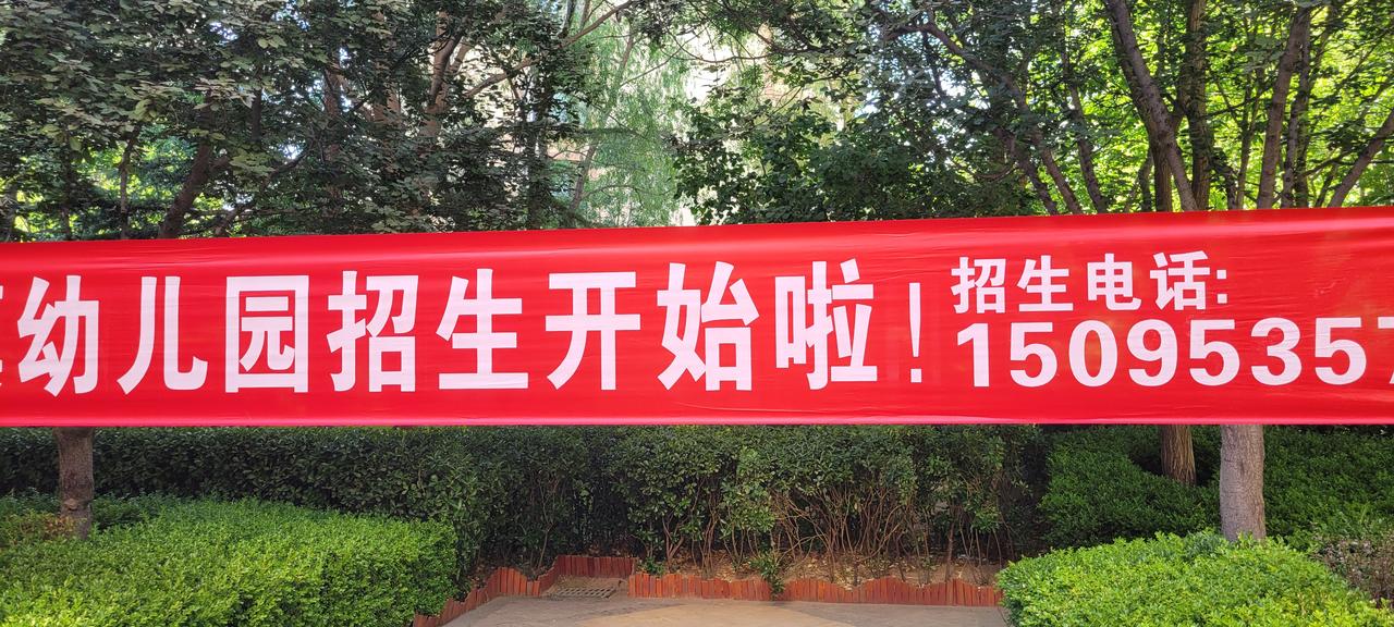 今天上午11:05分返回小区，发现这个已经悬挂一个多月幼儿园招生宣传横幅，还挂在