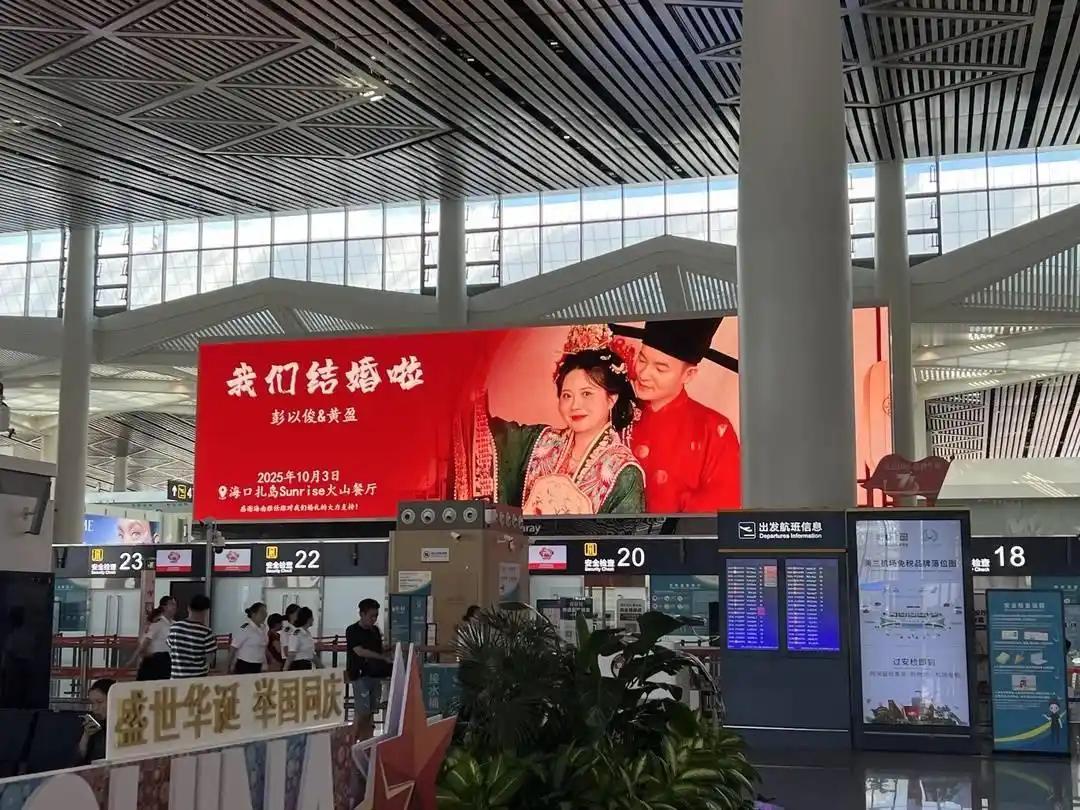 “有钱任性！”海南海口，一对新人结婚，除了在酒店摆酒席，还在机场租下88块大屏，