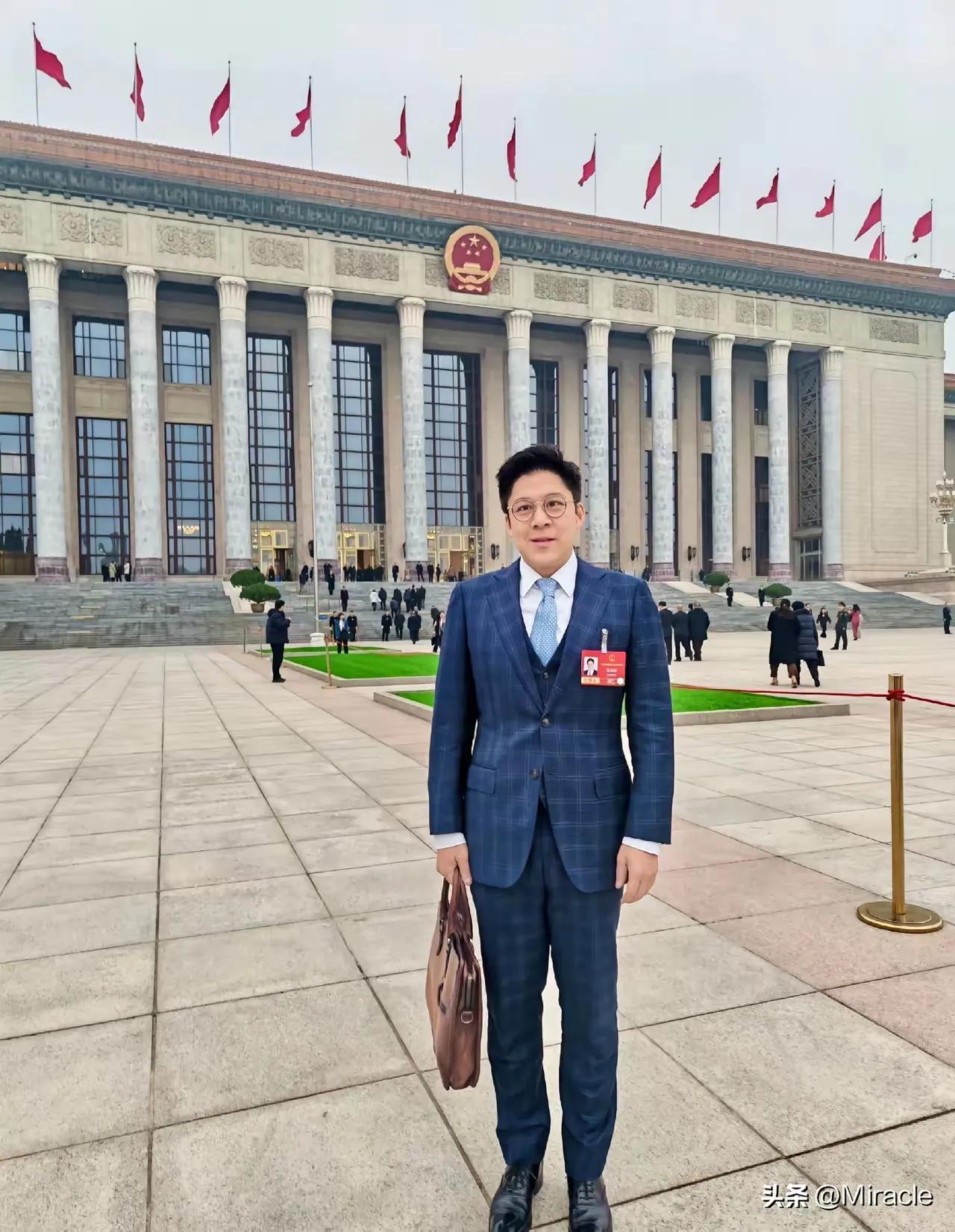 一身笔挺西装，手持公文包，霍启刚站在人民大会堂前，气场沉稳又坚定。他是霍英东家族