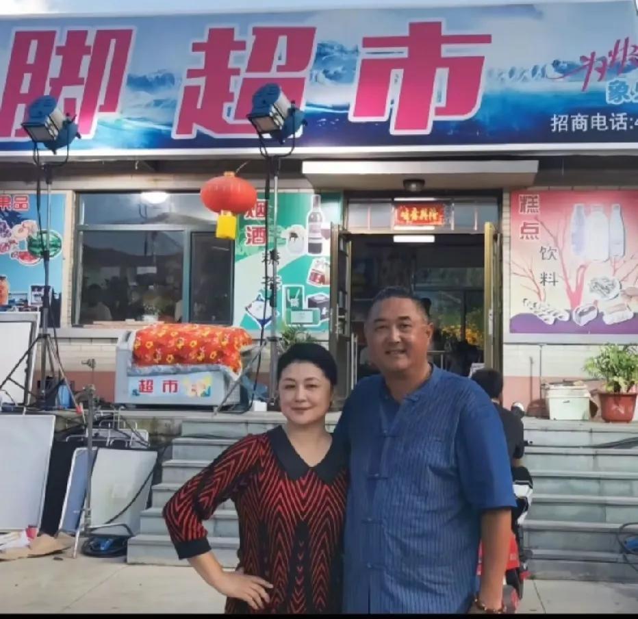 于月仙生前与丈夫张雪松在“乡村爱情”拍摄基地大脚超市门前的一张留影，于月仙是深受