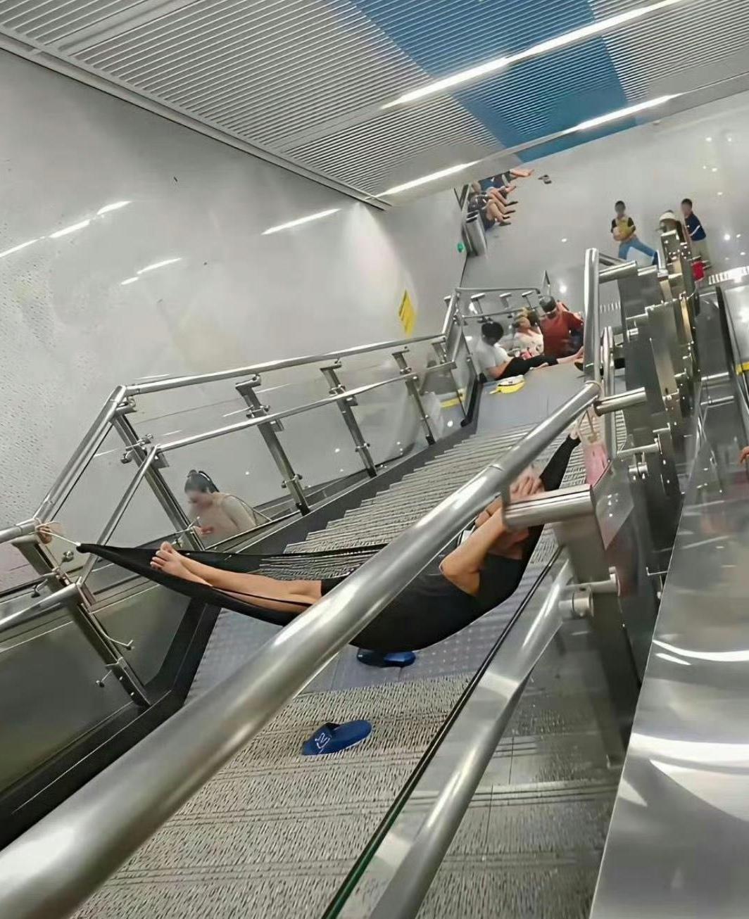地铁站市民蹭空调，在上下楼梯间弄个吊床，存在安全隐患

夏日炎炎，酷暑难耐。不少