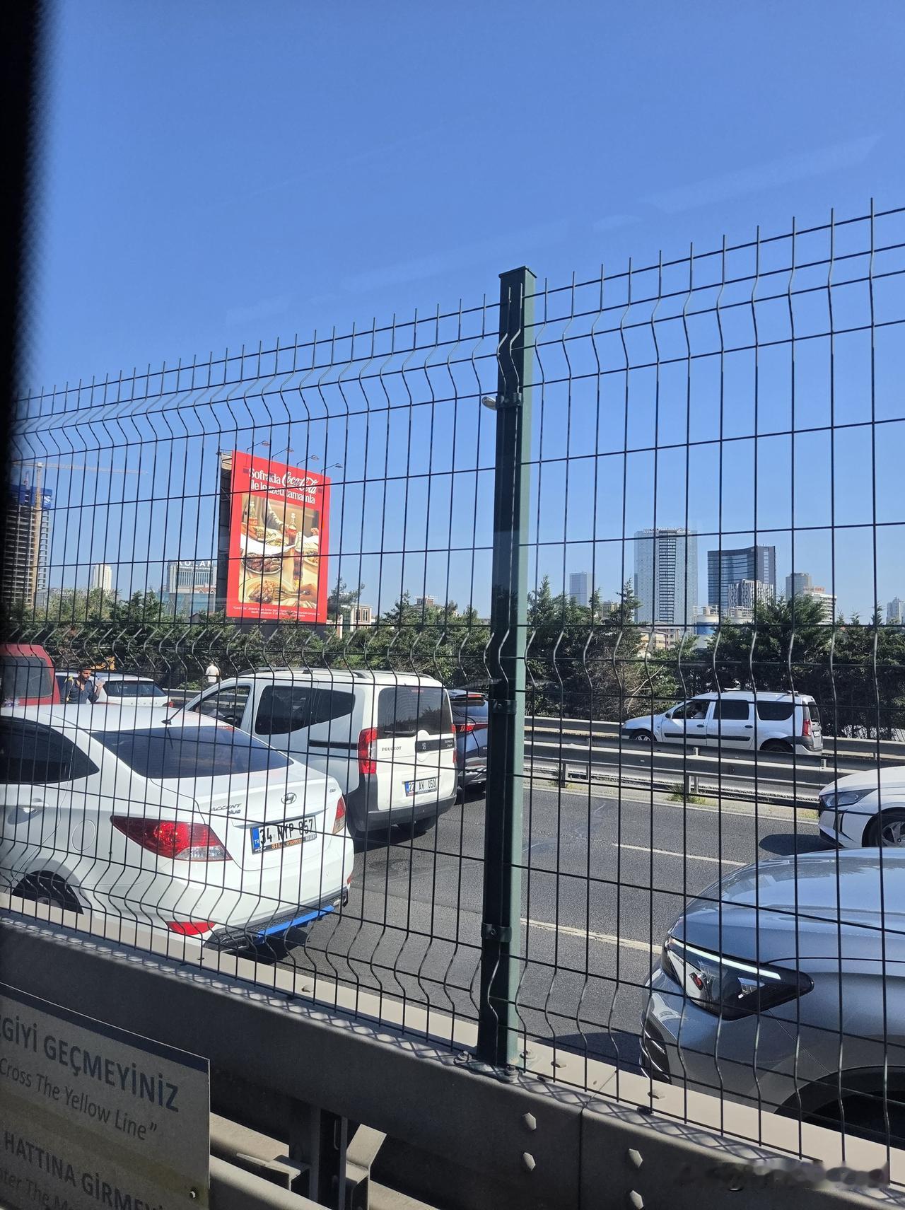 生活不易，横跨海峡的引桥上，一中年男人在车流滚滚中推销矿泉水。就在特朗普大厦旁边