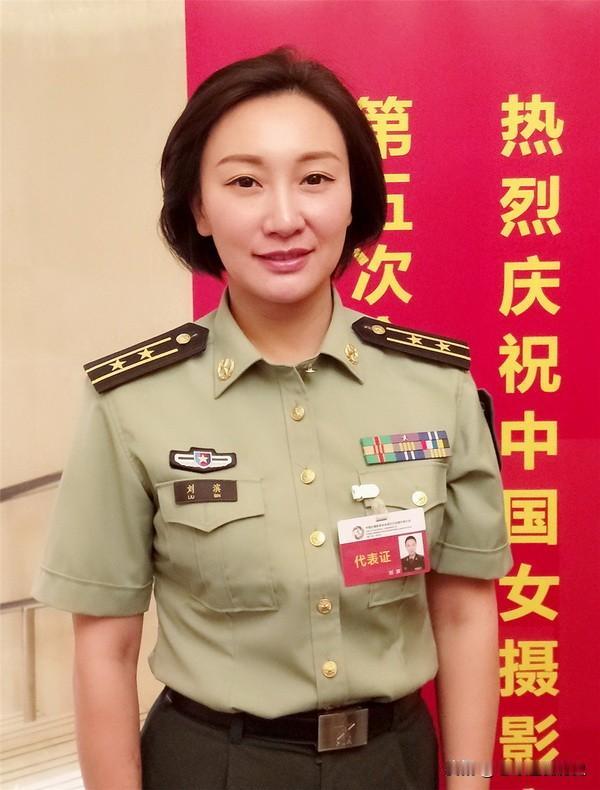 这张照片拍摄于中国女摄影家协会第五次全国代表大会现场，身着军装的刘滨佩戴代表证，