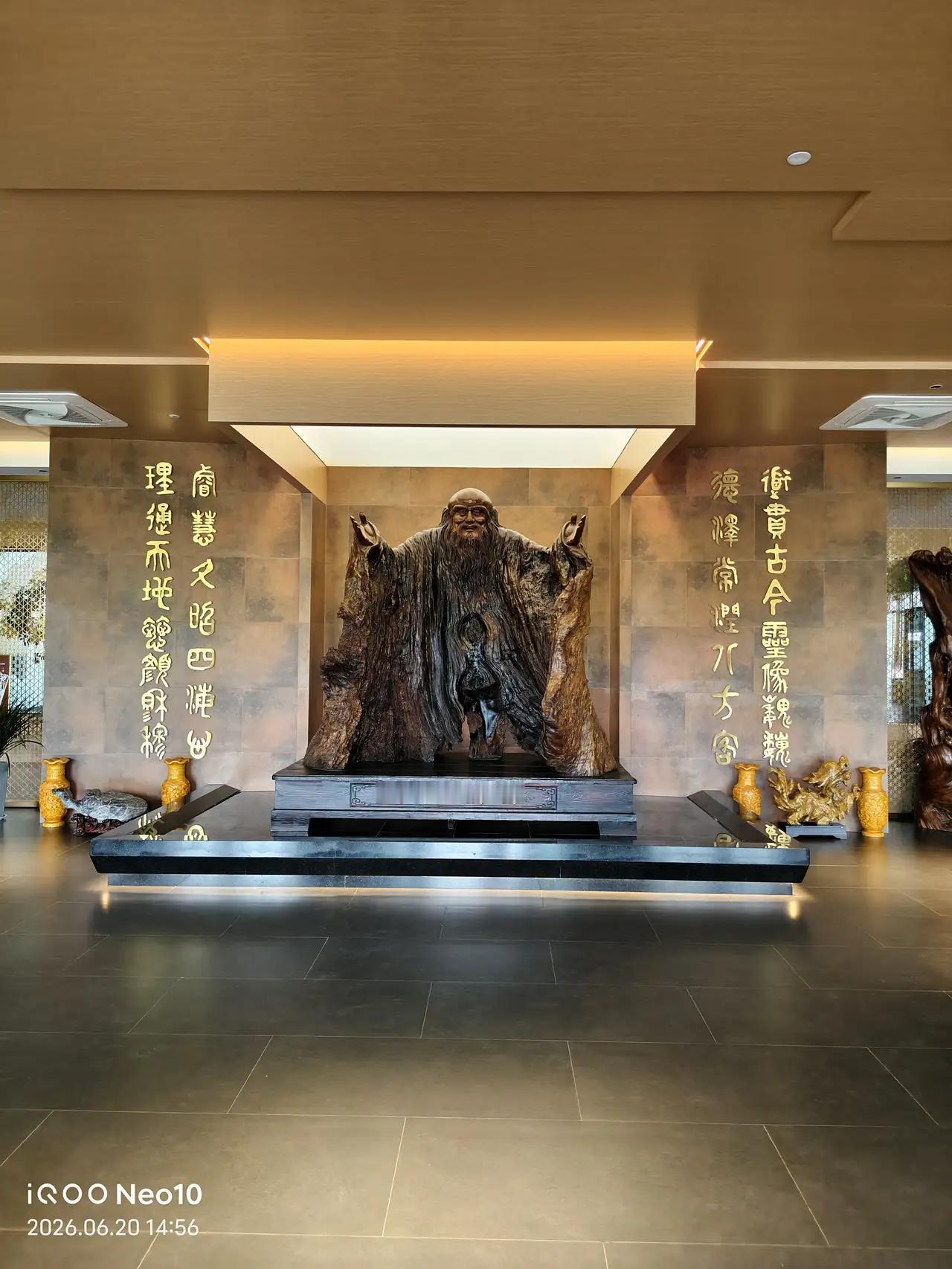 这是一尊老子木雕：
上联：道貫古今靈像巍巍，德澤常潤八方客
下联：理通天地懿颜穆