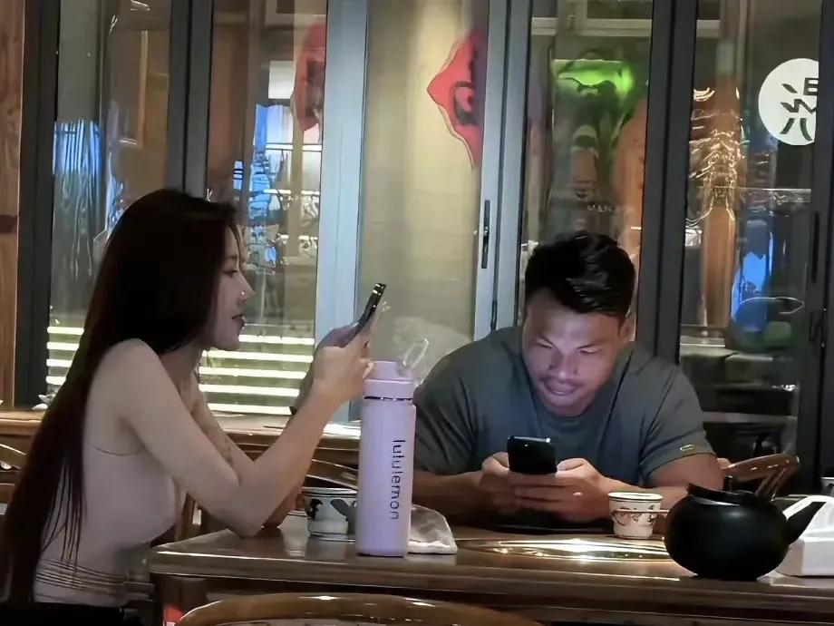 美女与野兽！互不打扰，沉浸在各自的手机世界里。